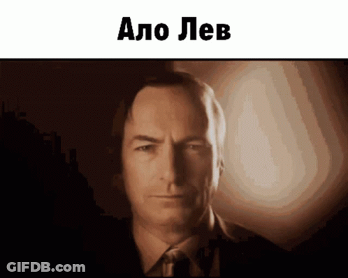Man In Suit And Tie Looking At Camera Says Alo Lev GIF