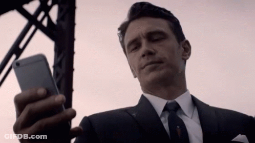 Man In Suit And Tie Looking At Phone GIF