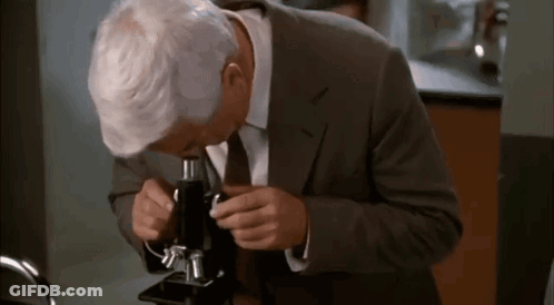 Man In Suit And Tie Looking Through Microscope In Lab GIF