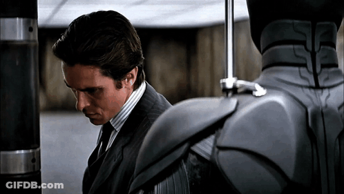 Man In Suit And Tie Next To Gray Robot GIF