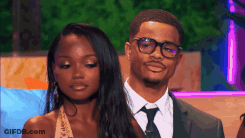 Man In Suit And Tie Next To Woman Wearing Glasses GIF