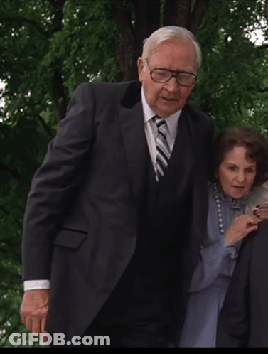 Man In Suit And Tie Next To Woman With Pearls GIF