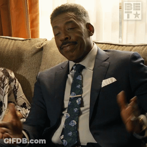 Man In Suit And Tie On Couch With BET Logo GIF