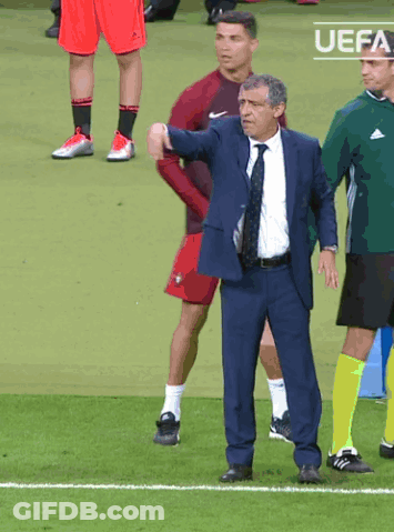 Man In Suit And Tie On Soccer Field With UEFA Logo GIF
