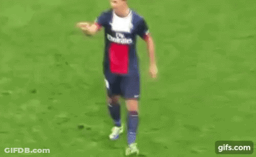 Man In Suit And Tie On Soccer Field With UEFA Logo GIF