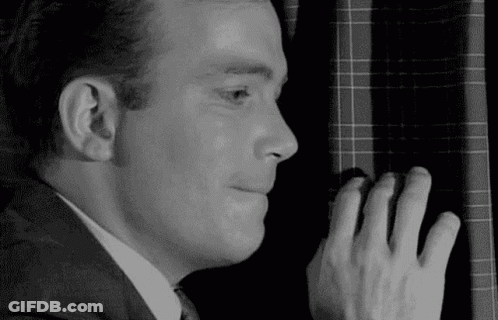 Man In Suit And Tie Peeking Behind Window GIF