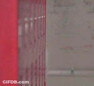 Man In Suit And Tie Peeking From Red Locker GIF