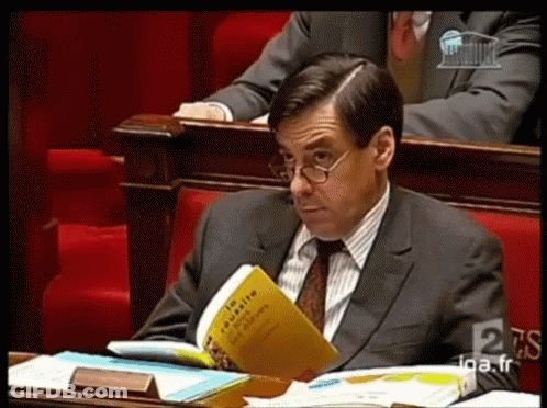 Man In Suit And Tie Reading En Masse GIF