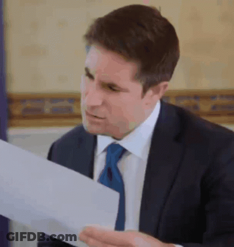 Man In Suit And Tie Reading Paper GIF