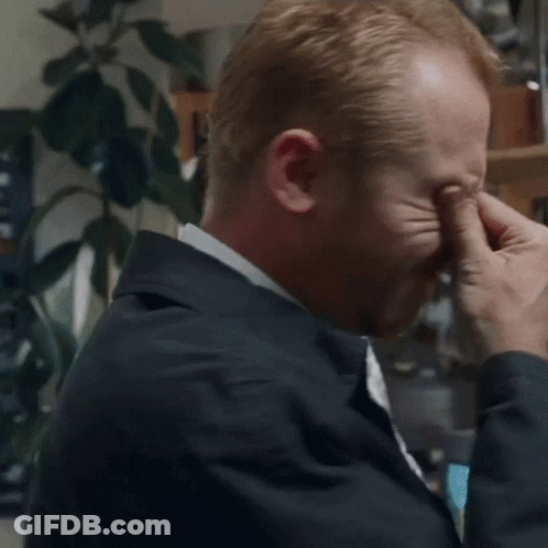 Man In Suit And Tie Rubbing Eyes GIF