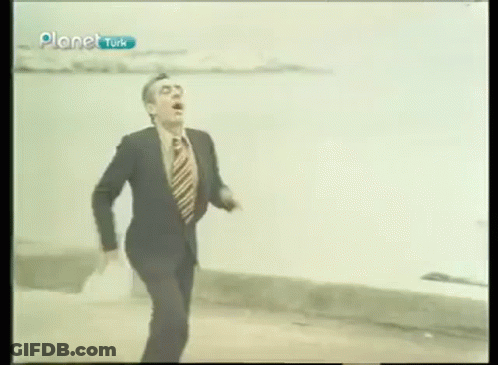 Man In Suit And Tie Running Across Street GIF