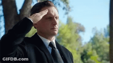 Man In Suit And Tie Salutes GIF