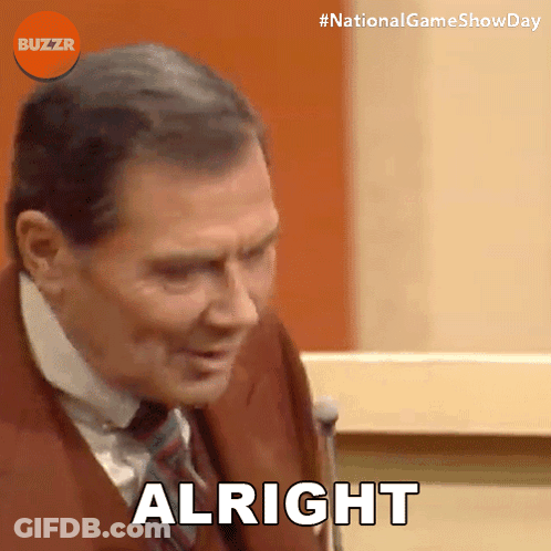 Man In Suit And Tie Saying Alright In Front Of Microphone GIF