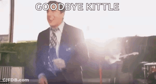Man In Suit And Tie Saying Goodbye Kittle In Front Of Guitar GIF