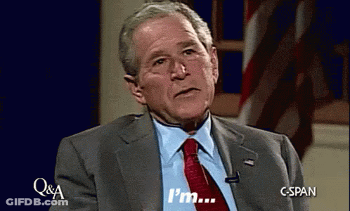Man In Suit And Tie Saying Im In Front Of American Flag GIF