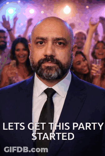 Man In Suit And Tie Saying Let's Get This Party Started GIF