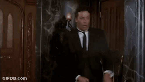 Man In Suit And Tie Says Oh Good Shot Green In Front Of Statue GIF
