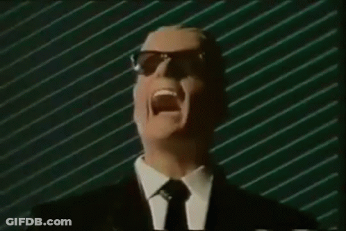 Man In Suit And Tie Screaming Into Mic With Sunglasses GIF