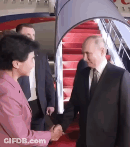 Man In Suit And Tie Shaking Hands With Woman In Pink Suit GIF