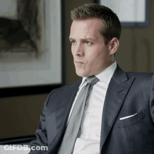 Man In Suit And Tie Sitting At Desk GIF