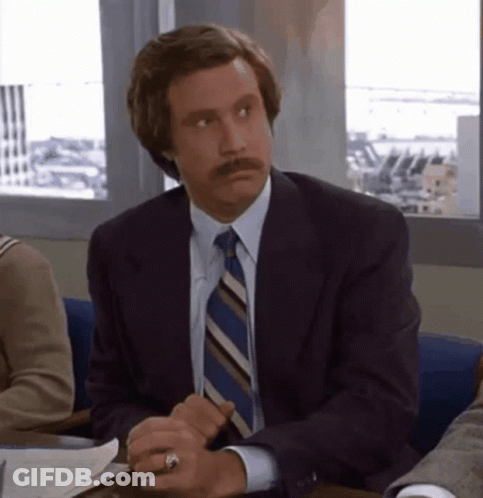 Man In Suit And Tie Sitting At Desk GIF