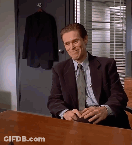 Man In Suit And Tie Sitting At Desk With Hands Folded GIF