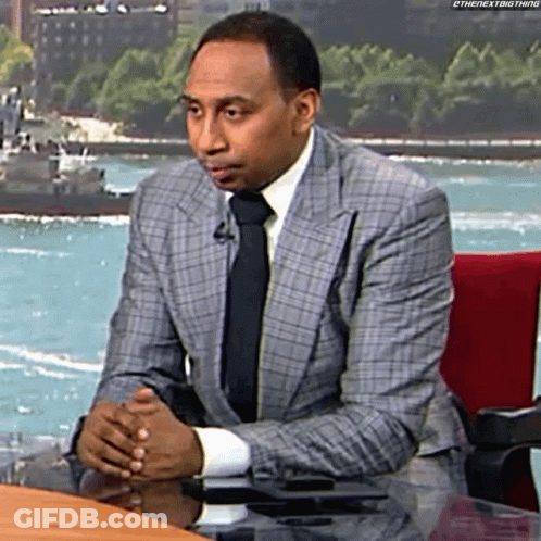 Man In Suit And Tie Sitting At Desk GIF
