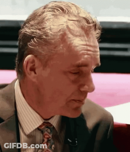 Man In Suit And Tie Sitting At Pink Table GIF