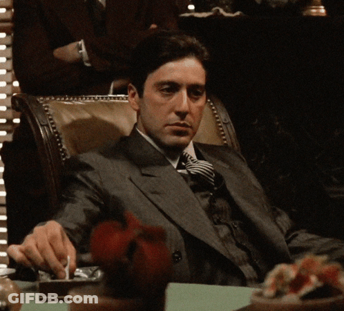 Man In Suit And Tie Sitting At Table GIF
