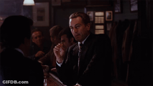 Man In Suit And Tie Sitting At Table GIF