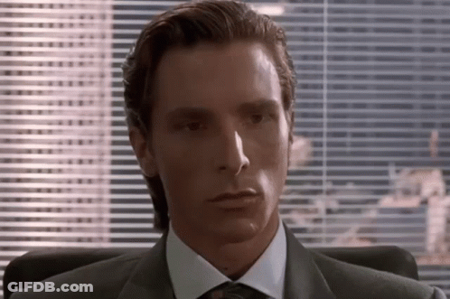 Man In Suit And Tie Sitting By Blinds GIF
