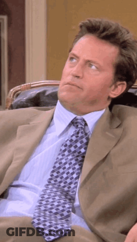Man In Suit And Tie Sitting Down GIF