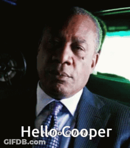 Man In Suit And Tie Sitting In Car Saying Hello Cooper GIF