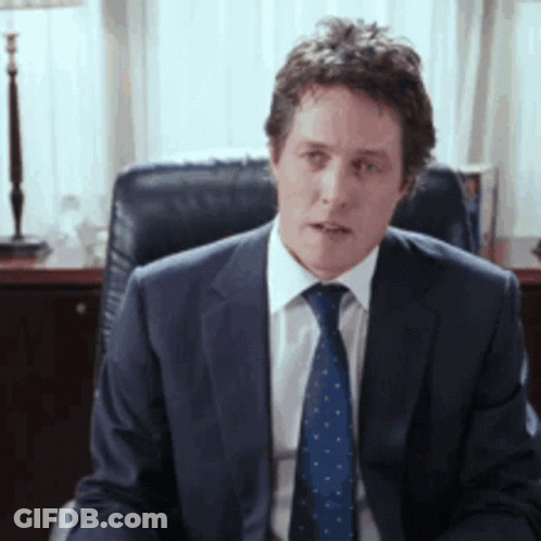 Man In Suit And Tie Sitting In Chair GIF