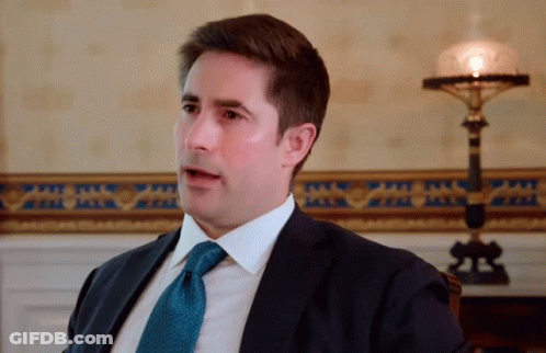 Man In Suit And Tie Sitting In Chair GIF
