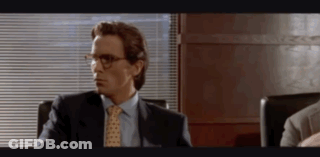 Man In Suit And Tie Sitting In Chair By Window GIF