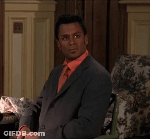 Man In Suit And Tie Sitting In Chair GIF