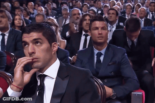 Man In Suit And Tie Sitting In Crowd GIF