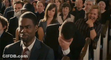 Man In Suit And Tie Sitting In Crowd GIF