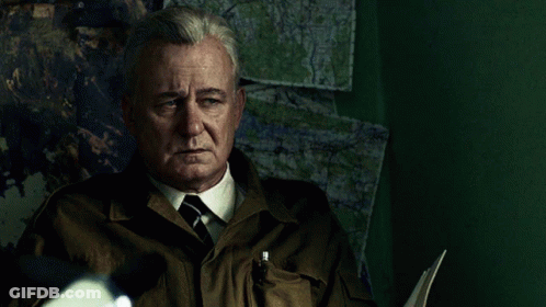 Man In Suit And Tie Sitting In Front Of Map Wall GIF
