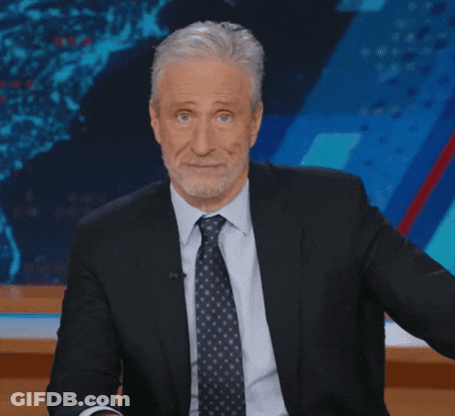 Man In Suit And Tie Sitting In Front Of Screen GIF