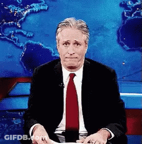 Man In Suit And Tie Sitting In Front Of World Map GIF