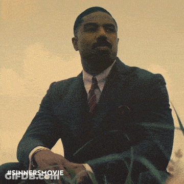 Man In Suit And Tie Sitting In Grass GIF