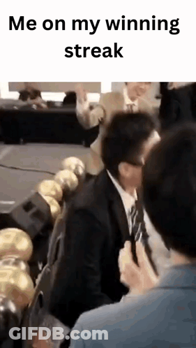 Man In Suit And Tie Sitting In Row Of Chairs GIF