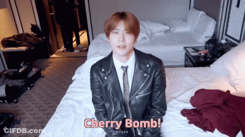 Man In Suit And Tie Sitting On Bed Cherry Bomb GIF