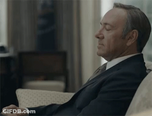 Man In Suit And Tie Sitting On Couch GIF