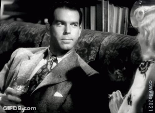 Man In Suit And Tie Sitting On Couch GIF