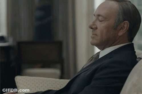 Man In Suit And Tie Sitting On Couch GIF