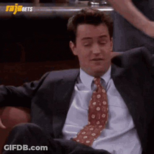 Man In Suit And Tie Sitting On Couch With Legs Crossed GIF