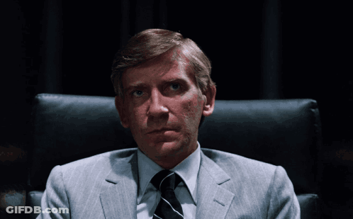 Man In Suit And Tie Sitting With Hands Folded GIF